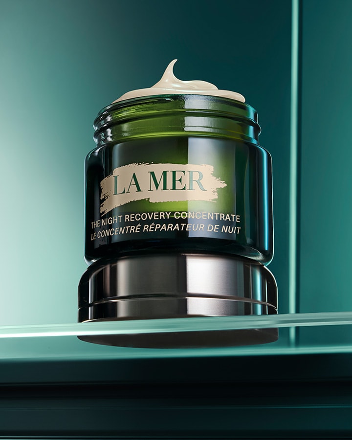 An open jar of The Night Recovery Concentrate resting on a glass shelf