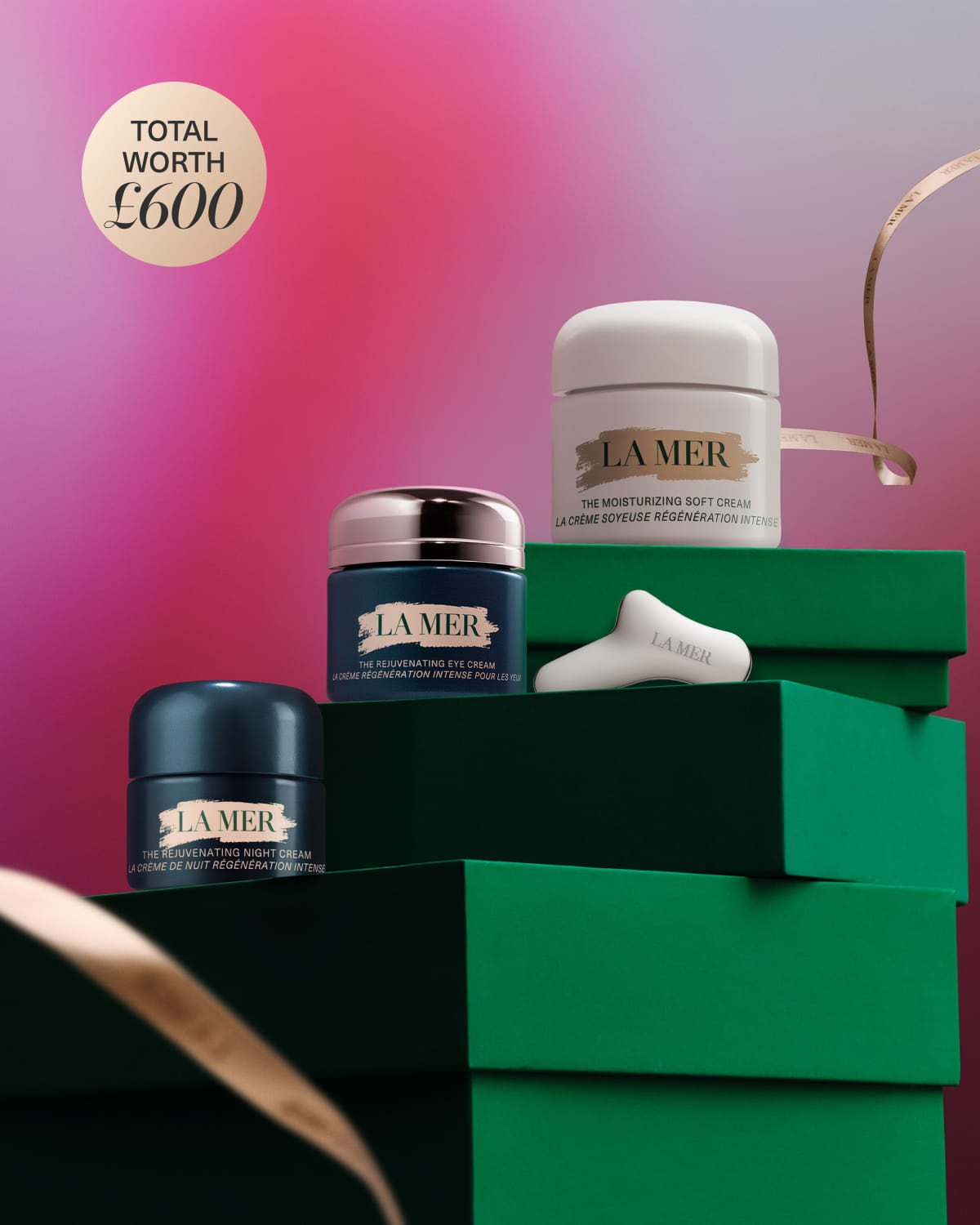 La Mer skincare gift set displayed on white blocks with a teal bag and products worth £242.