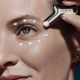 Close up of model applying The Eye Concentrate to under eyes using applicator