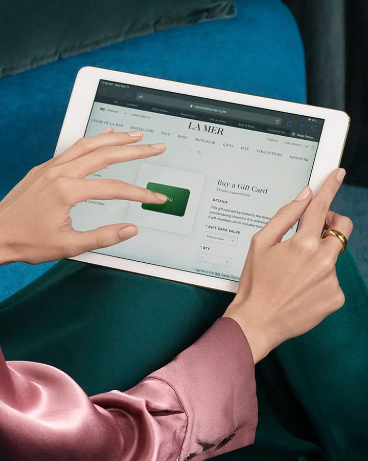 Woman's hands holding an ipad ordering a la mer e gift card