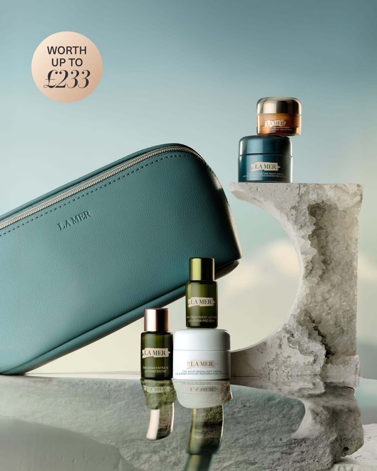 La Mer skincare gift set displayed on white blocks with a teal bag and products worth £185