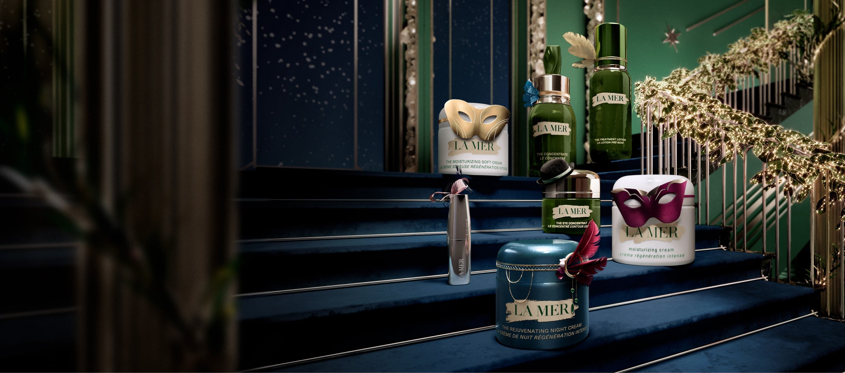 Selection of bestselling La Mer products placed on a festive, grand staircase, decorated in miniature masquerades and headwear