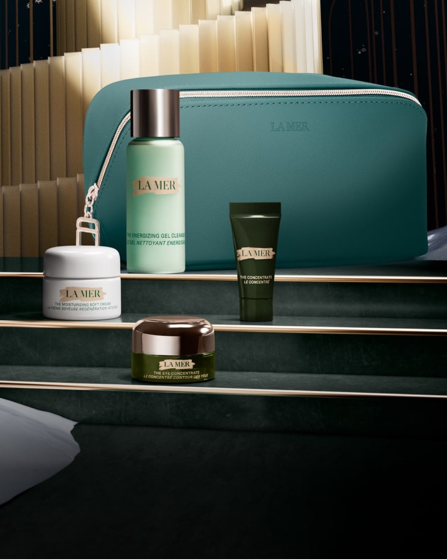 Selection of La Mer minis in a dynamic, twilight lit setting, with The Eye Concentrate mini on a glass shelf