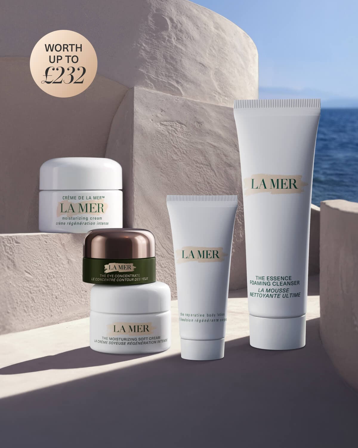 La Mer skincare gift set displayed on white blocks with a teal bag and products worth £242.