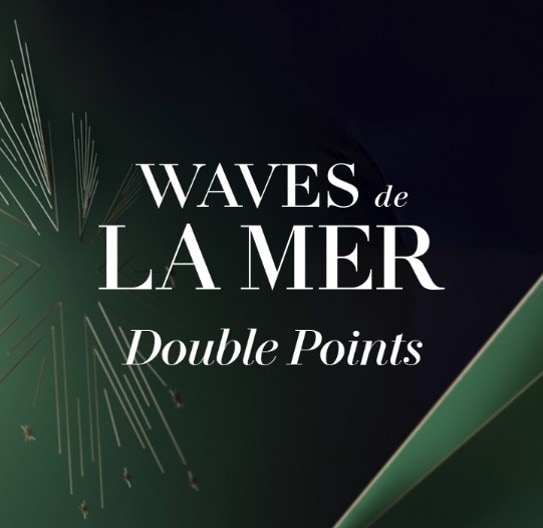 La Mer skincare gift set displayed on white blocks with a teal bag and products worth £242.